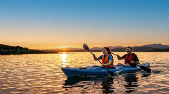 a bold composition focusing on the kayaker and her father in their kayak, framed against a breathtaking golden sunset. generous negative space is left above, ideal for