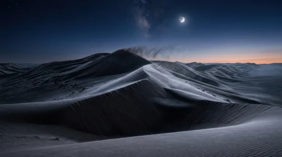 A wind-sculpted desert landscape of towering sand dunes at pre-dawn, the crests of dunes razor-sharp against a deep indigo sky still holding the last stars, a crescent