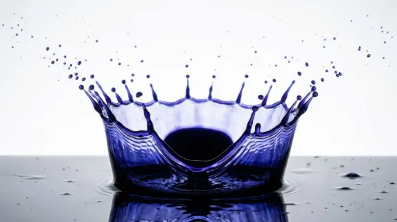 Frozen splash of deep indigo ink captured at the precise microsecond of maximum crown formation, the classic crown shape with perfect pointed spires rising symmetrically