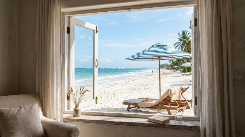 A serene beachfront view through a window, ocean and umbrella visible outside, soft indoor framing and quiet resort calm, ultra-realistic, no logos.
