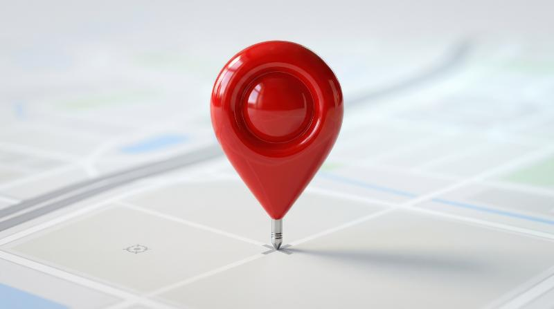 A shiny red location pin marking delivery coordinates, glossy finish, clean isolated composition, modern navigation atmosphere, ultra-realistic, no logos.