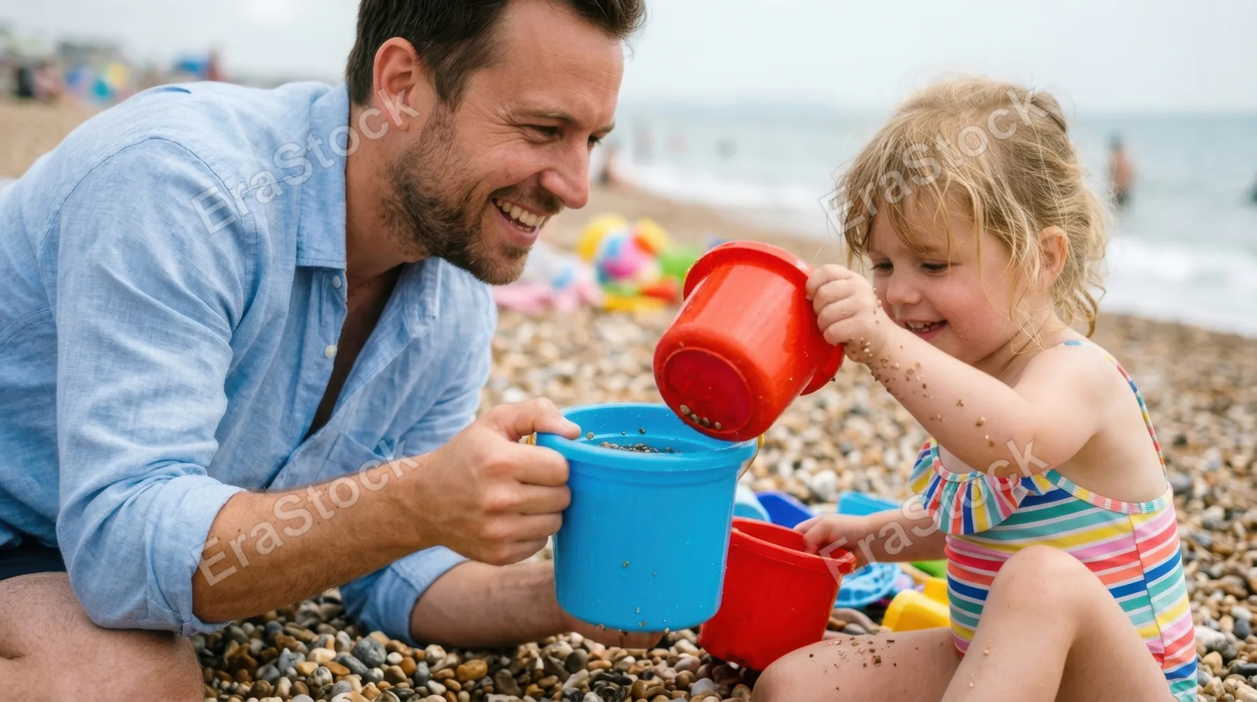 a tight focus on the bright blue container held by the smiling father, showcasing his engaged expression while his young daughter reaches for a red container beside her.