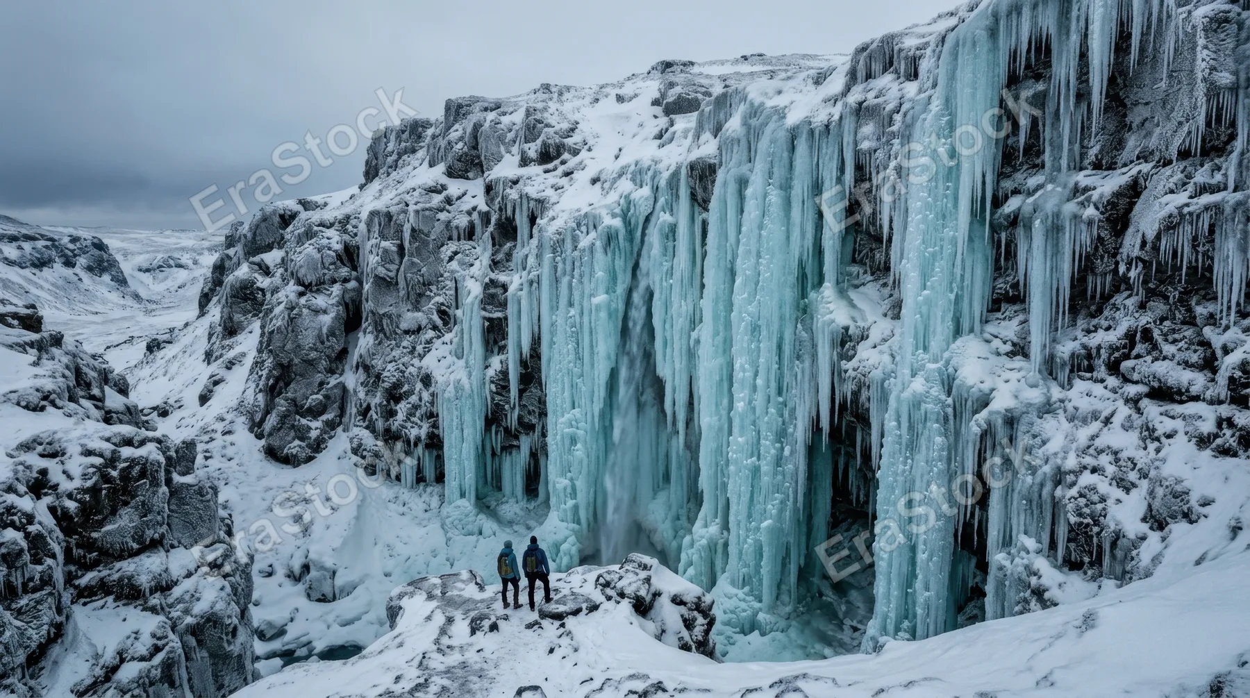 A frozen waterfall in mid-winter, the entire cascade locked in suspended motion with translucent blue-green ice columns of varying thickness descending from an unseen