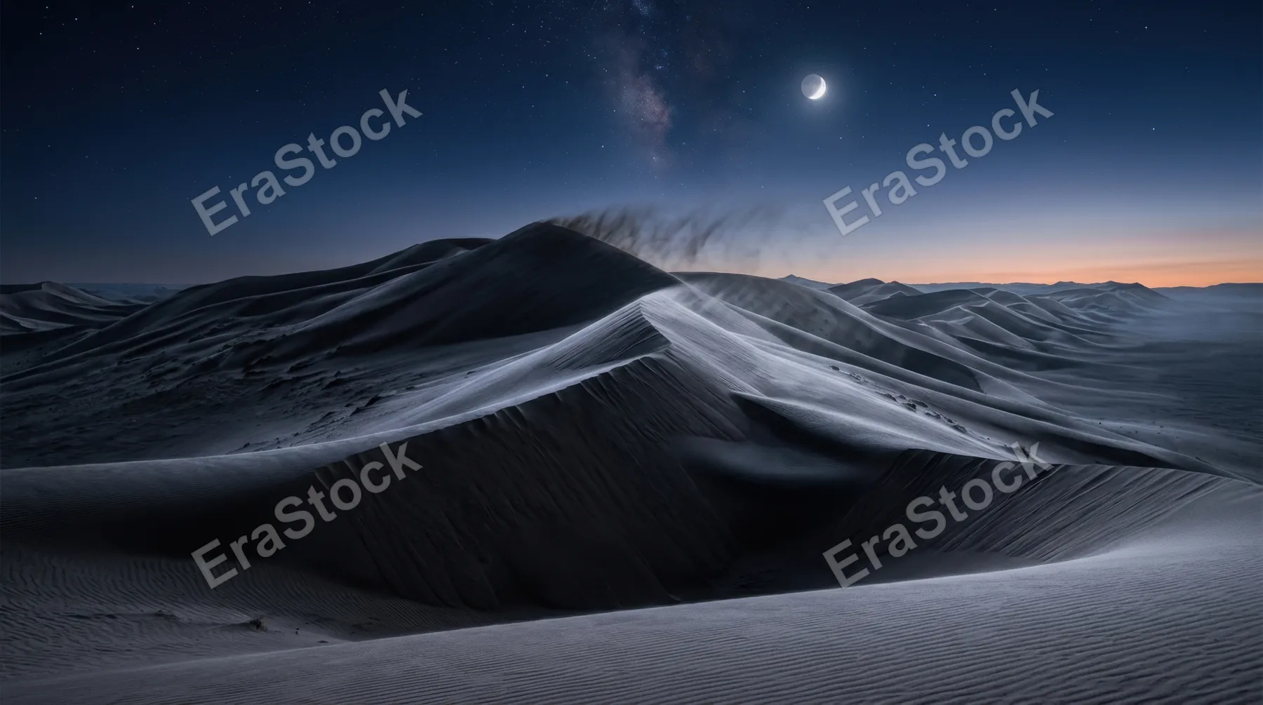 A wind-sculpted desert landscape of towering sand dunes at pre-dawn, the crests of dunes razor-sharp against a deep indigo sky still holding the last stars, a crescent