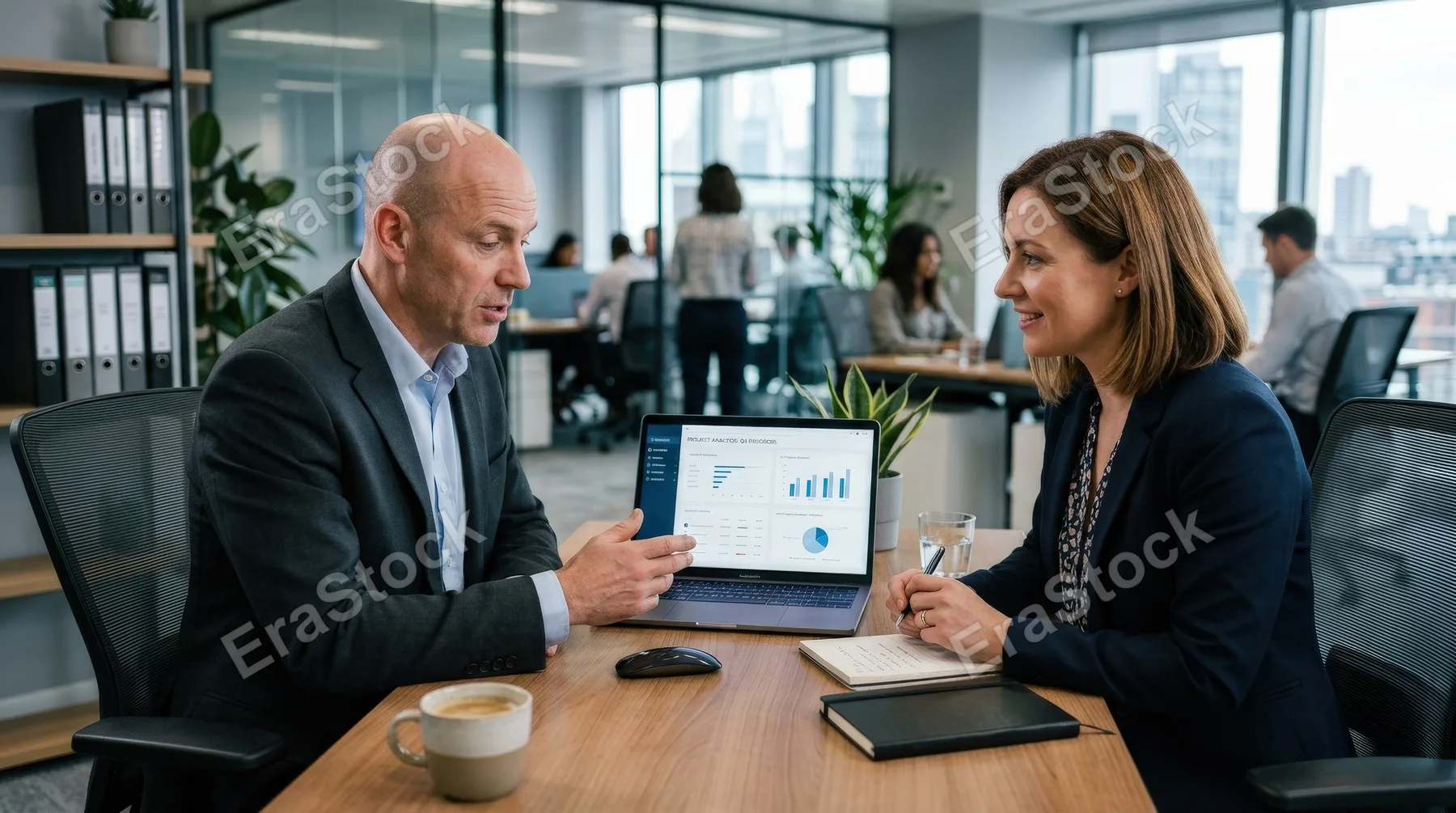 A bald businessman discussing work over a computer with a female colleague in an office, attentive expressions, sleek desk setup, cool office tones, collaborative atmosphere, ultra-realistic, no