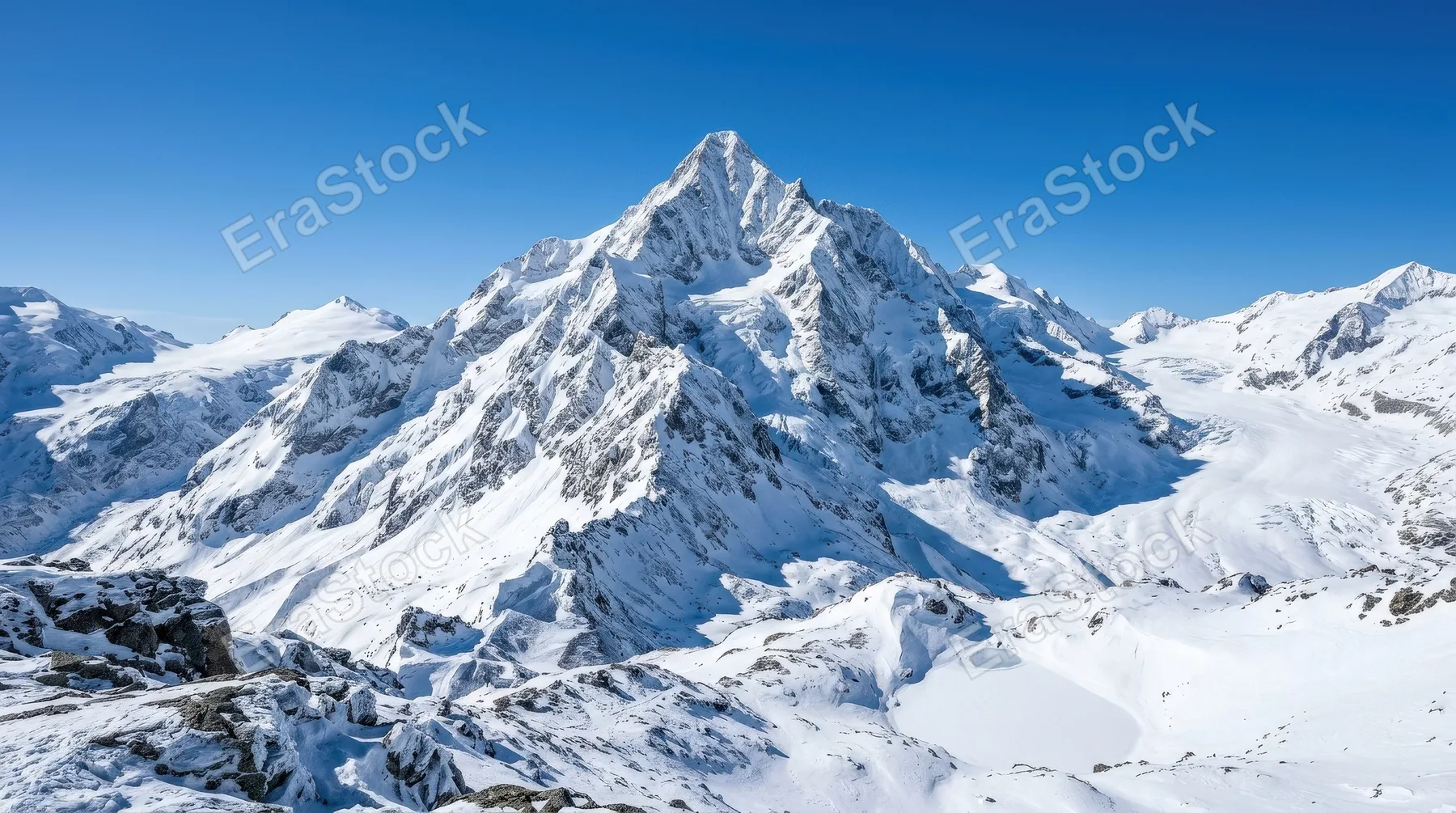 A snow-covered mountain peak beneath a clear sky, icy ridges, crisp alpine air and majestic winter stillness, ultra-realistic, no logos.
