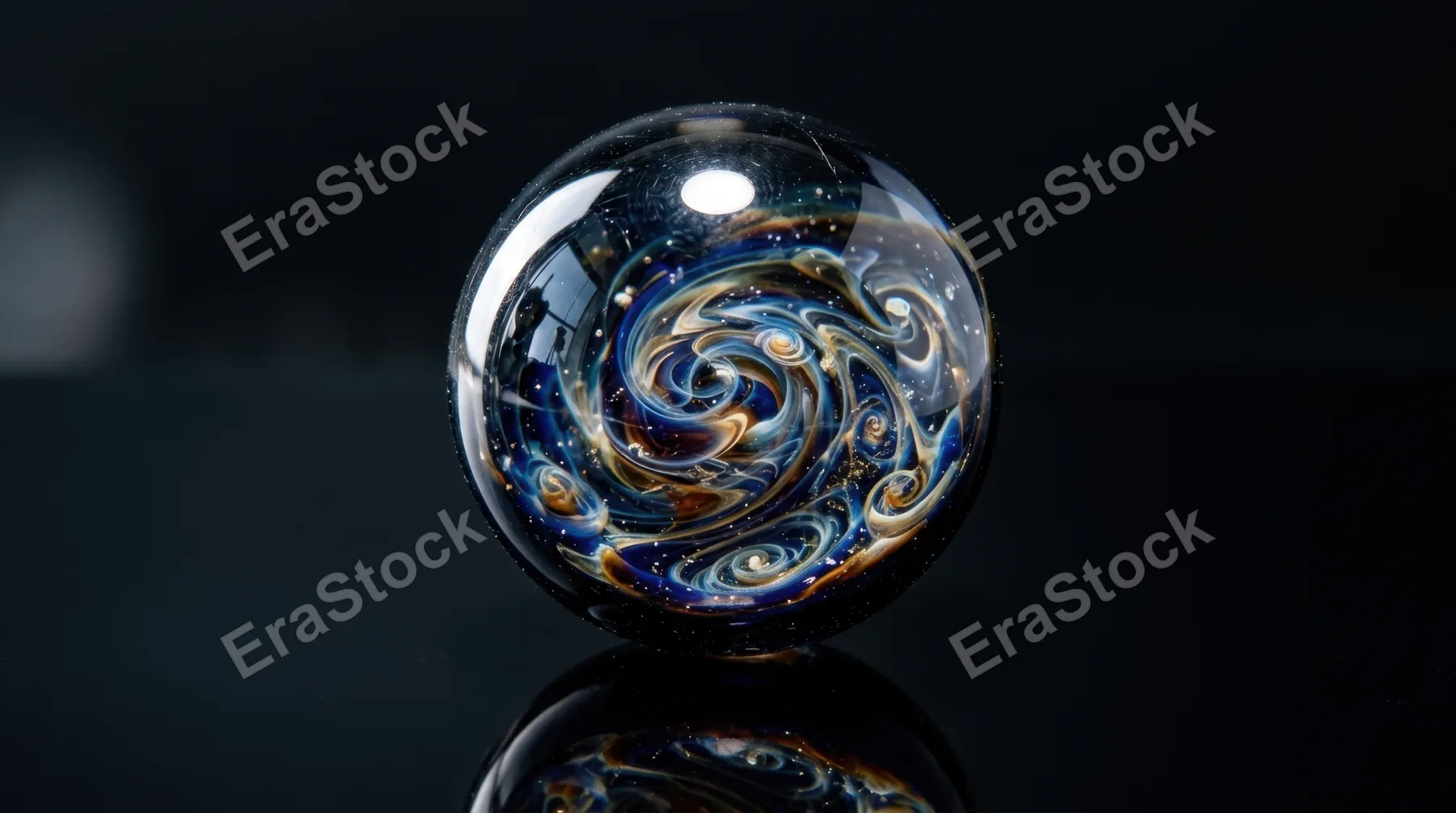 An extreme close-up of a glass marble resting on a dark mirror surface, the interior of the marble containing a captured universe of swirling cobalt, amber and white