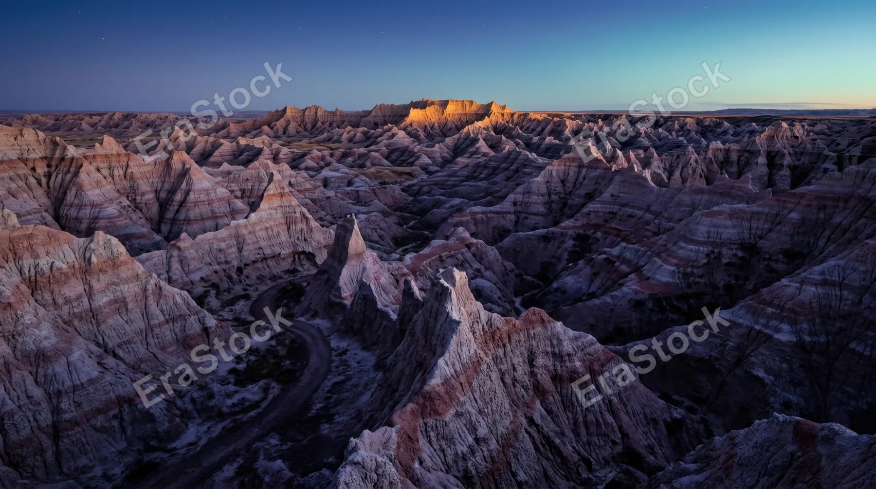 A dramatically eroded badlands landscape at blue hour, thousands of pointed clay pinnacles in banded layers of lavender, grey and terracotta extending to every horizon,