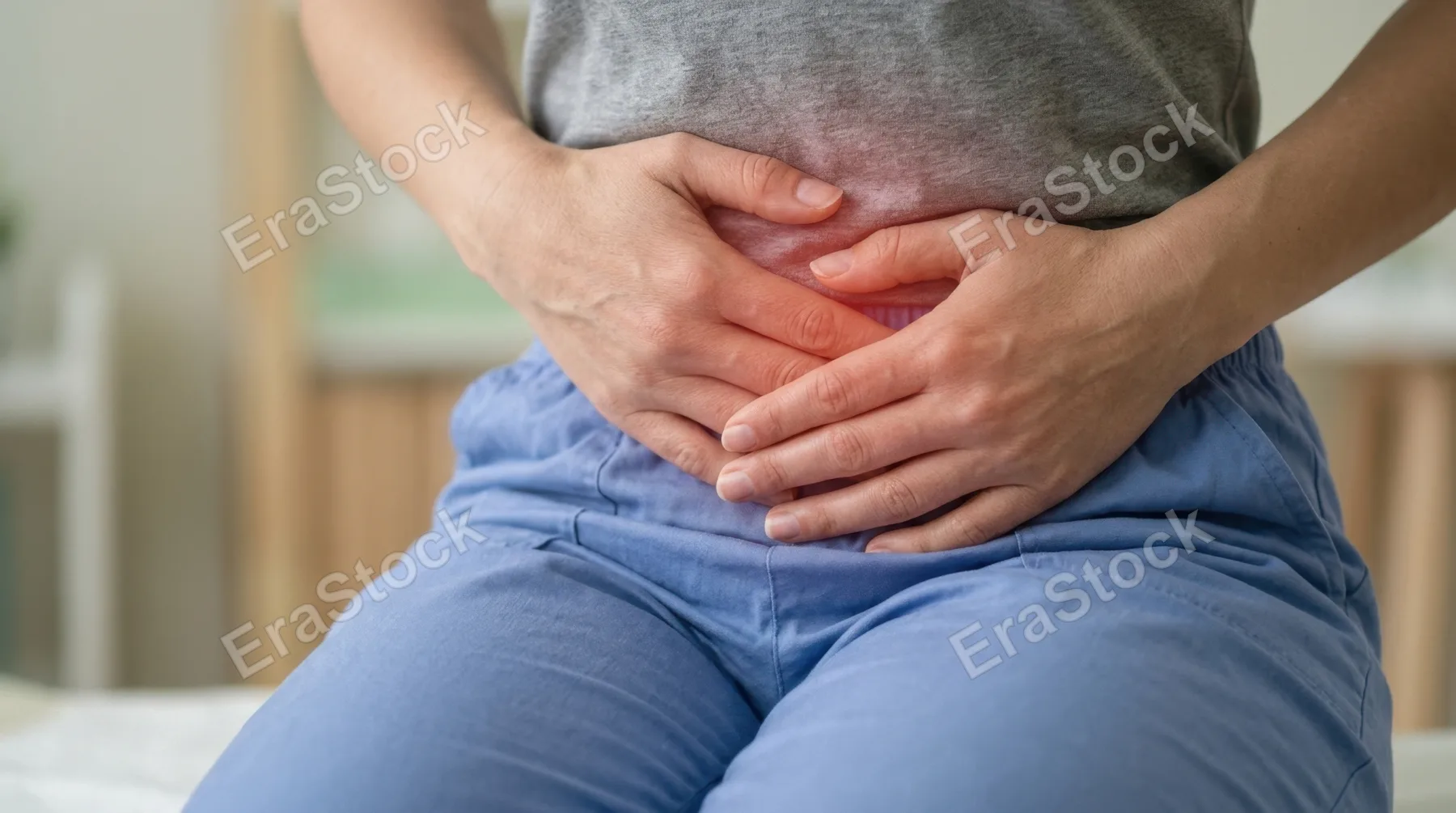 Close-up of a person holding their abdomen with a highlighted area indicating stomach pain, subtle red glow effect suggesting discomfort, neutral background softly