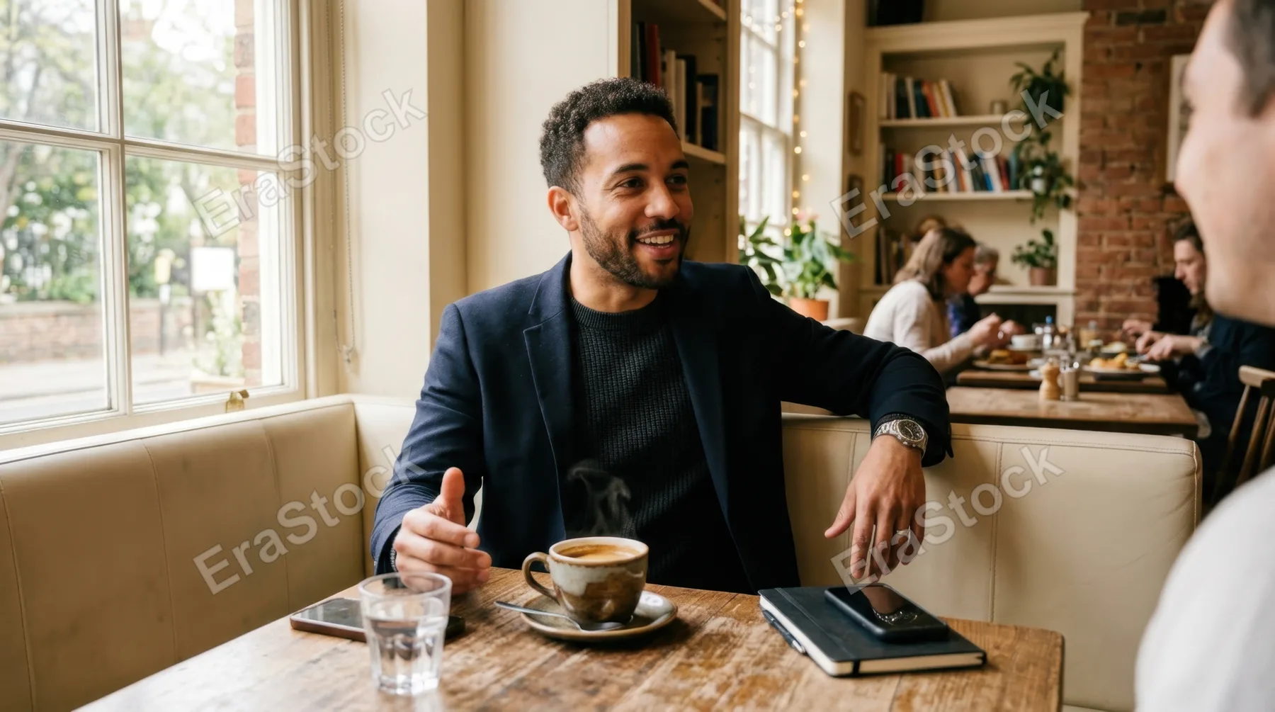 a 32-year-old mixed-race male consultant engaged in a candid conversation at a cozy cafe corner, with a steaming cup of rich espresso on the table. the environment