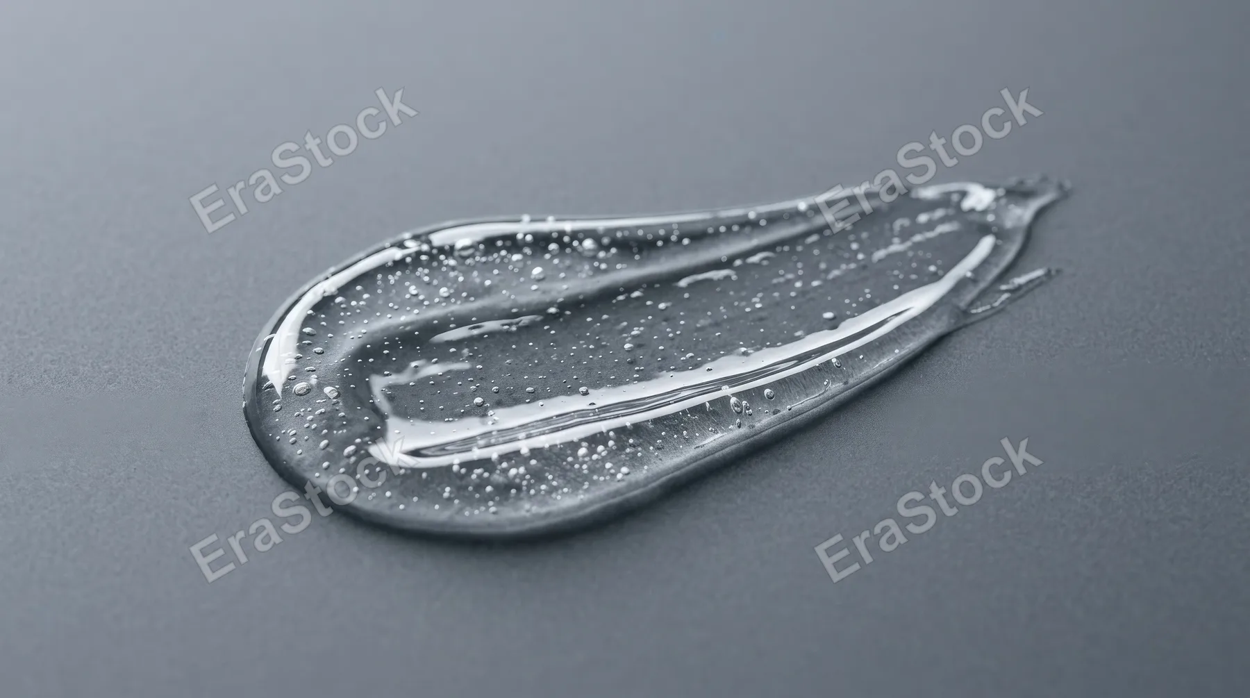 A clear skincare serum gel smear on a gray background, glossy translucent texture with tiny air bubbles, sleek cosmetic minimalism and clean scientific beauty mood, ultra-realistic, no logos.