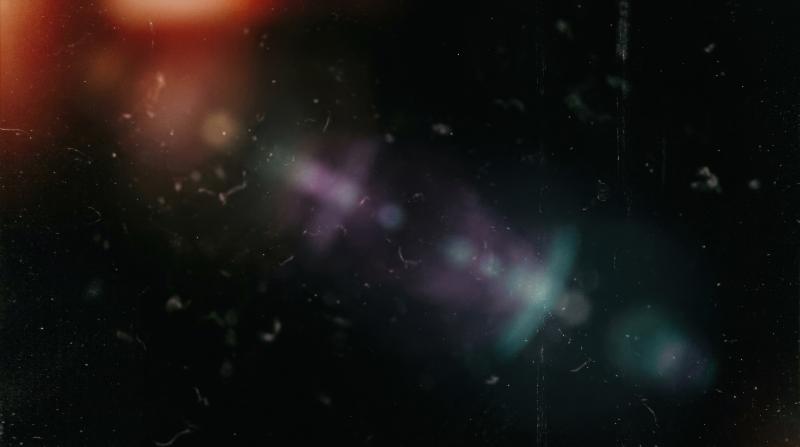 A black background with drifting dust, blurred leak light and nostalgic film flare, gritty analog burn and textured darkness, ultra-realistic, no logos.