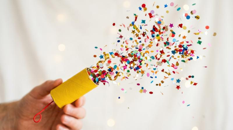 A yellow party popper emoji bursting with confetti, playful celebration and bright cheerful energy on a clean backdrop, ultra-realistic, no logos.