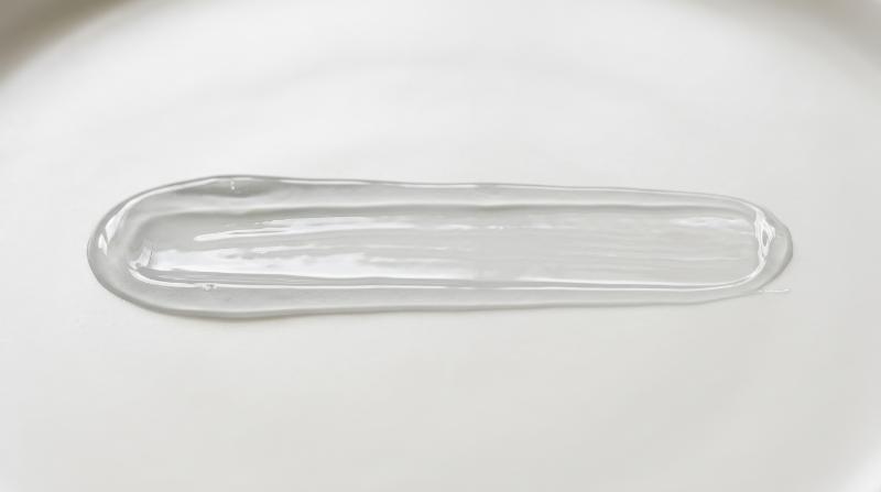 A straight horizontal light grey transparent gel smear with pure molecular clarity, smooth hydrated texture on a minimal background, clean scientific elegance, ultra-realistic, no logos.