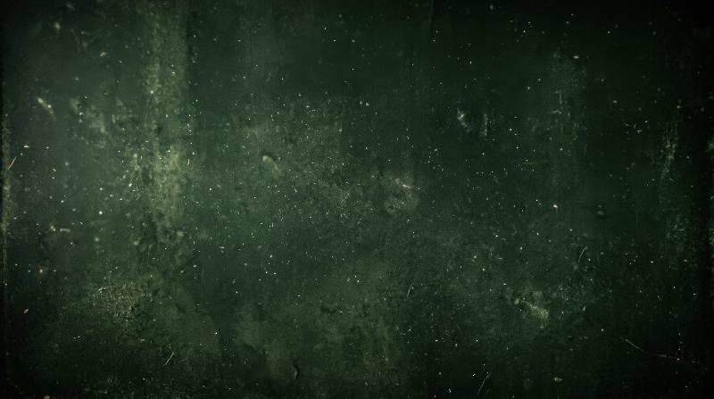 A dark green textured backdrop with floating dust particles, fine film grain and vintage grunge depth, moody retro atmosphere for poster-style design, ultra-realistic, no logos.